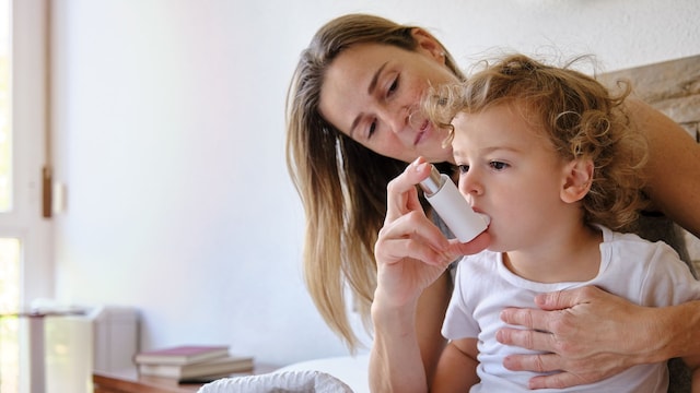 Madre pone inhalador a su hijo por una crisis de asma