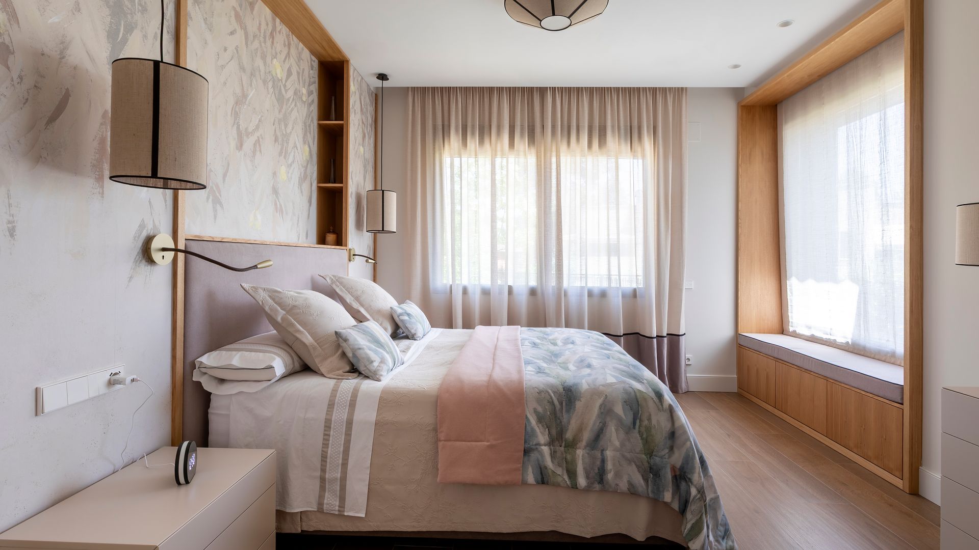 Dormitorio principal con cabecero a medida y banco delante de la ventana