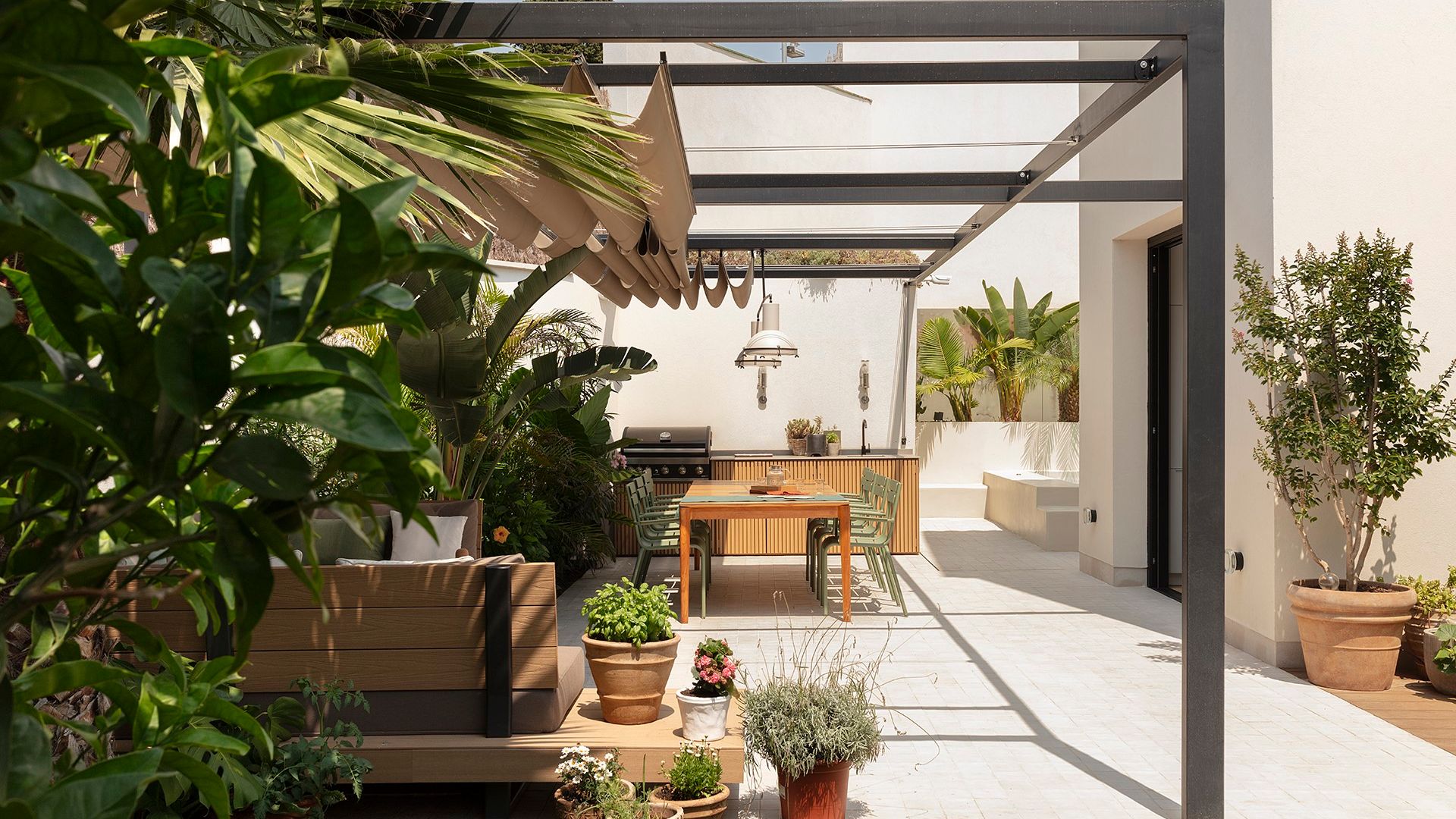 Exterior con pérgola, comedor y cocina de exterior en un proyecto de The Room Studio