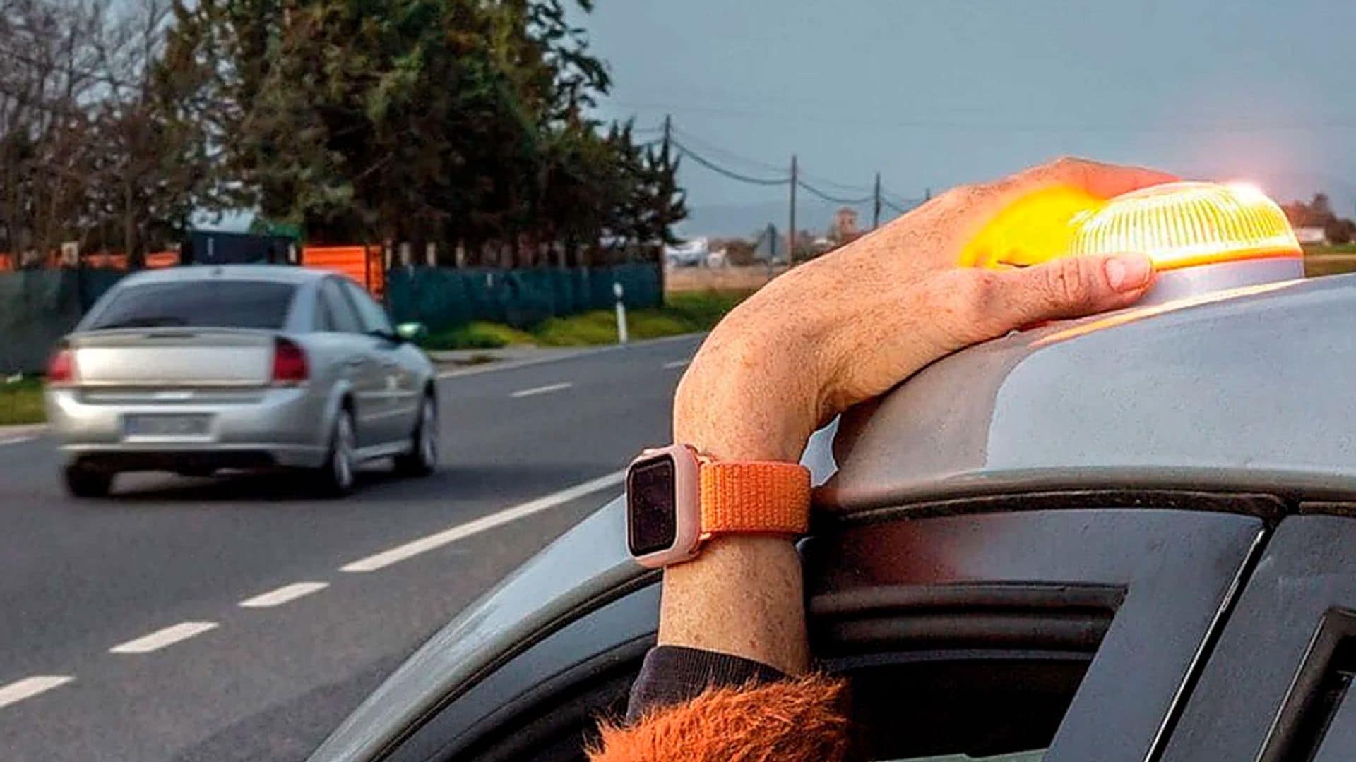 Una chica colocando una baliza encima de un coche