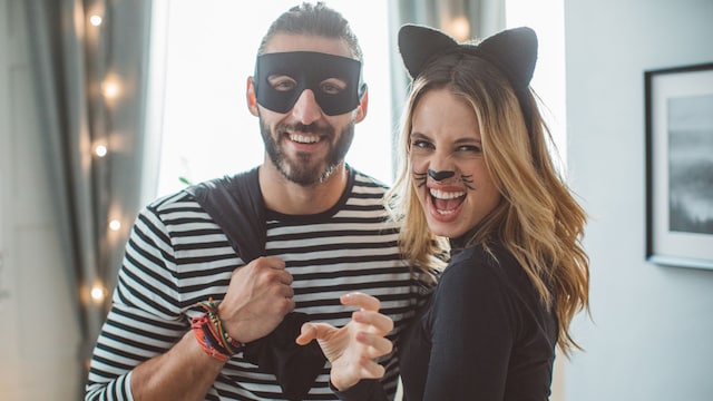 Pareja con disfraces de Halloween de gato y ladrón