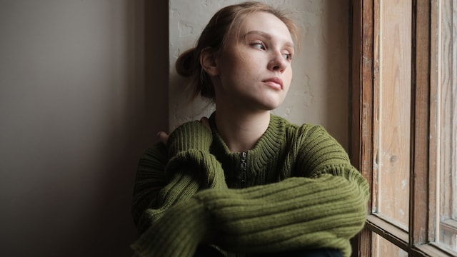 mujer triste y nostálgica mirando por la ventana