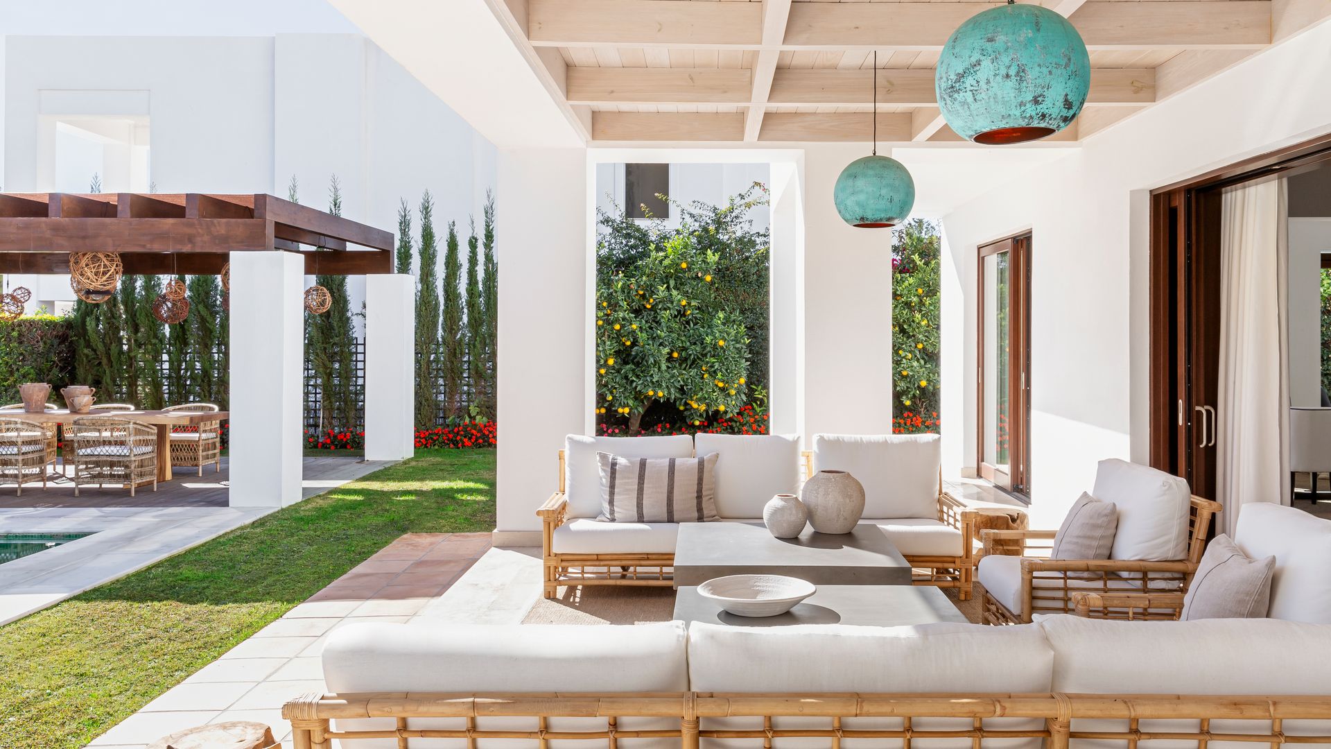 Porche casa con piscina con sofás blancos, lámparas de techo azules, techo de madera 
