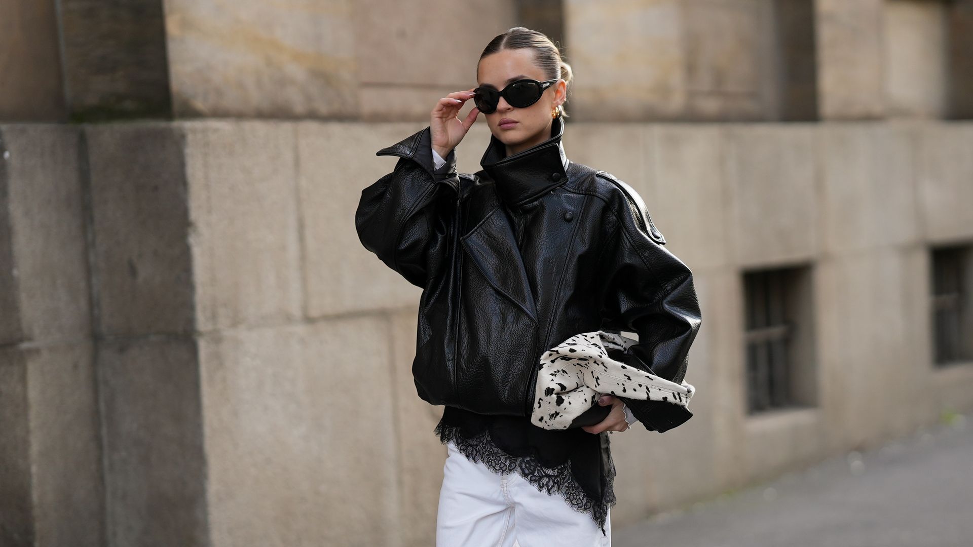 Look con cazadora oversize de cuero y vaqueros blancos