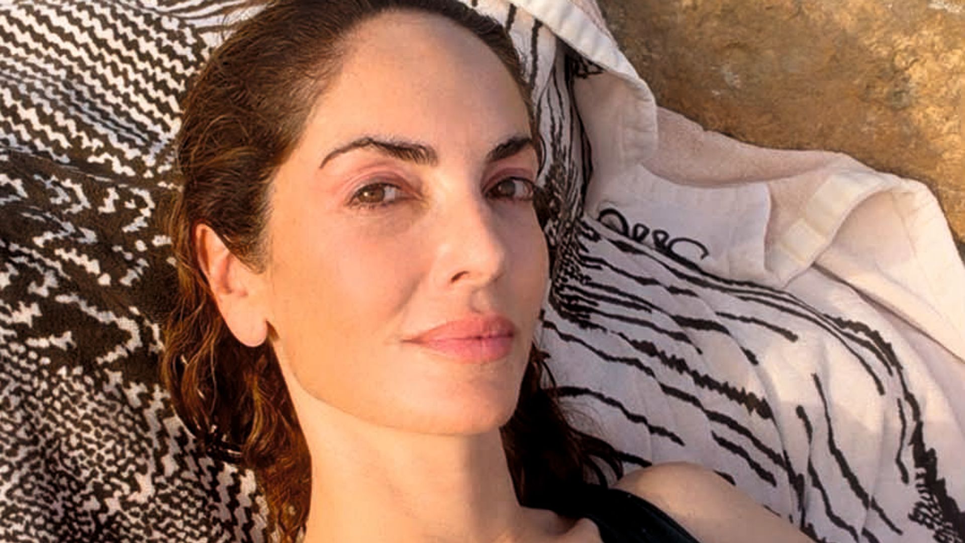 Eugenia Silva tumbada en la arena leyendo Maite