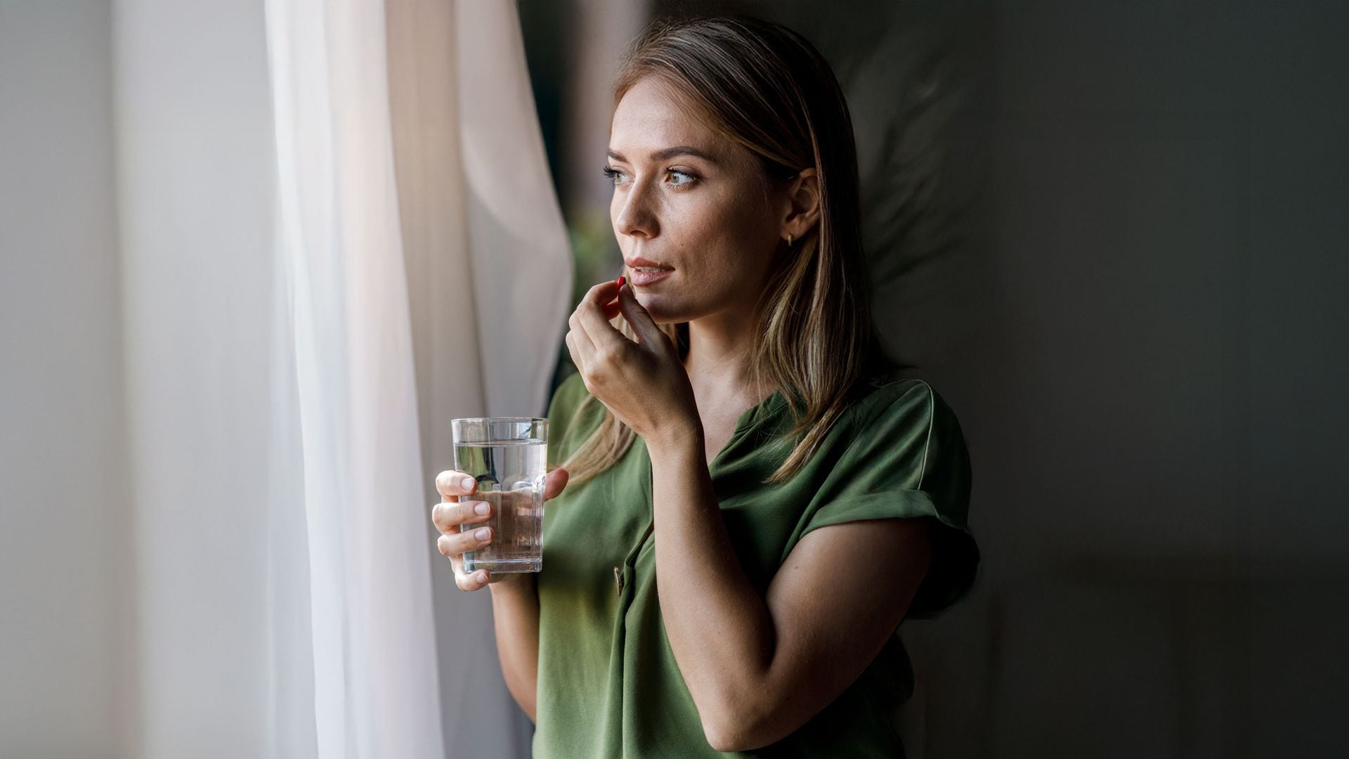 Una mujer tomando suplementos alimenticios