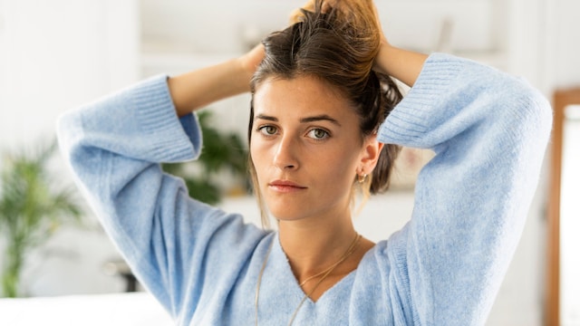 Mujer joven algo preocupada mirando a cámara 