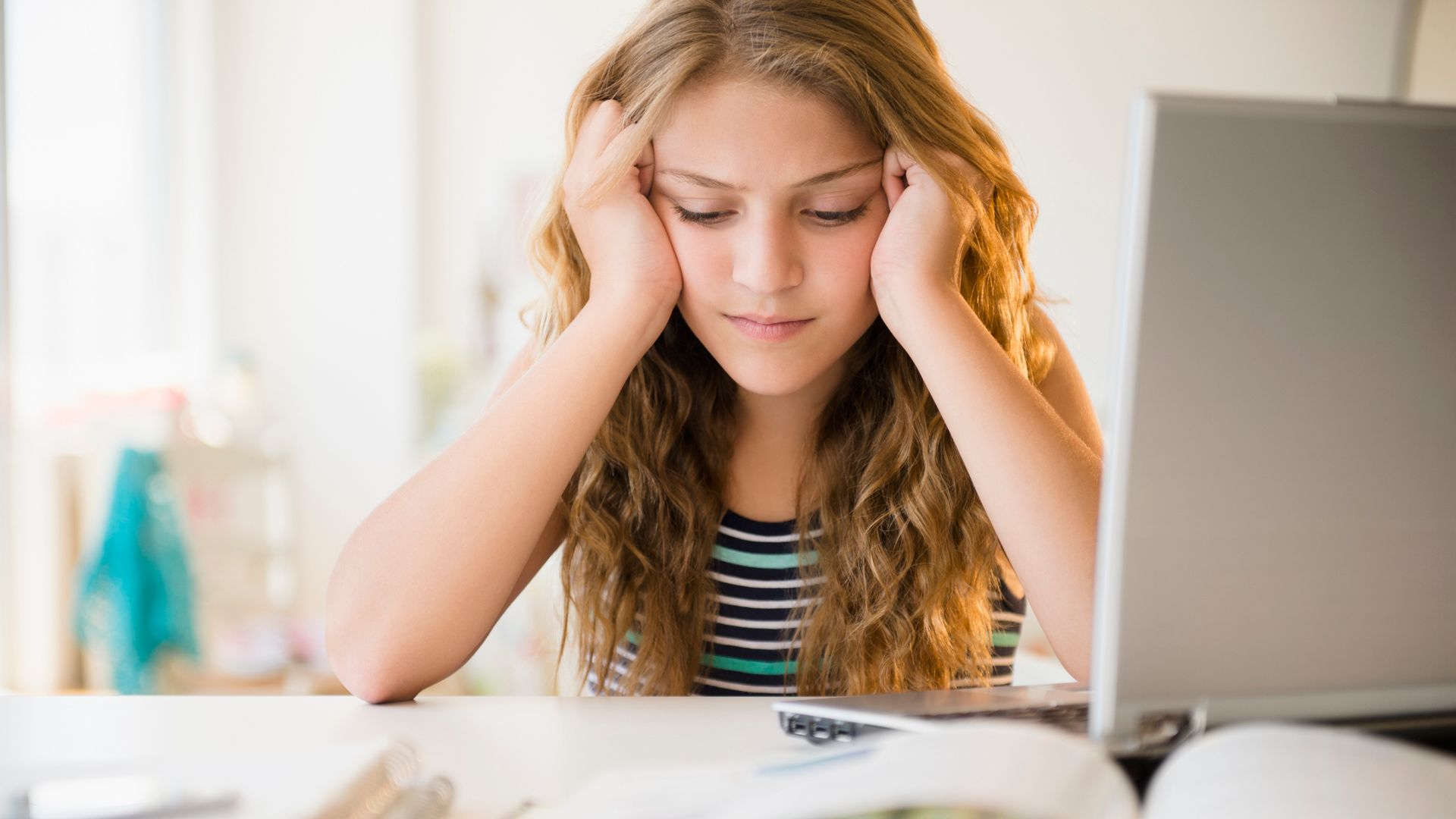 Estudiante adolescente agobiada delante de los libros