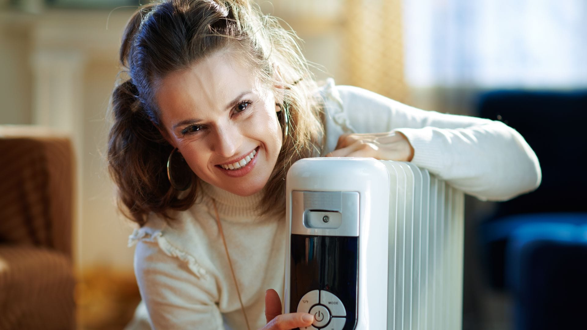 Mujer encendiendo radiador eléctrico
