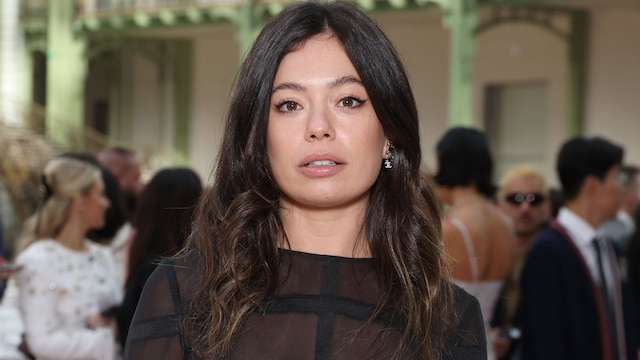 Anna Castillo con traje de falda y blusa negras con transparencias en el desfile de Chanel en París