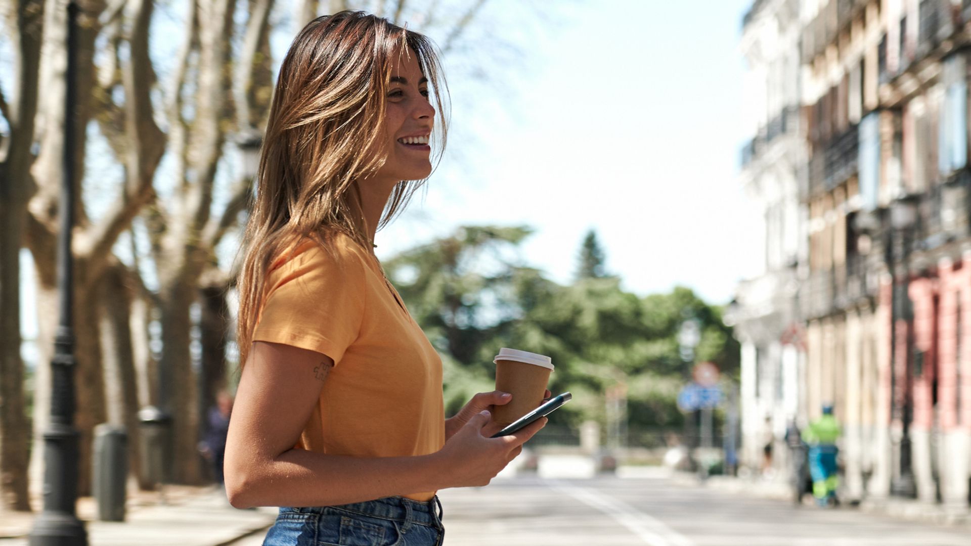 Mujer sonriendo cruzando la calle