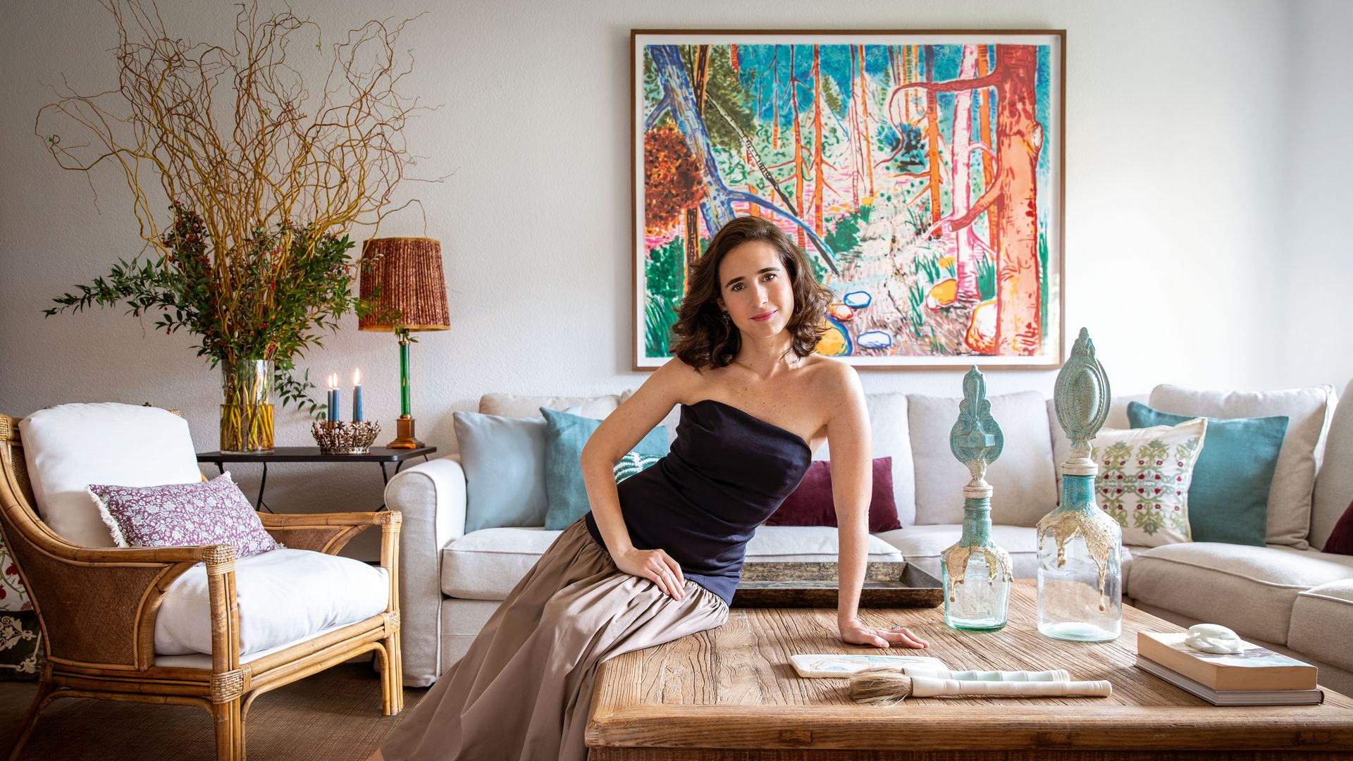 Sobre estas líneas, Mónica Remartínez posa en el salón de su casa en Madrid. Detrás luce un óleo del pintor Abraham Lacalle. Sobre la mesa, jarrones de Oficios de Ayer y tabla y pinceles egipcios de alabastro