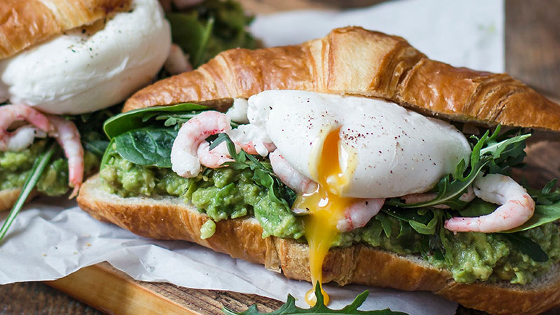 Croissant con aguacate, gambas y huevo poché