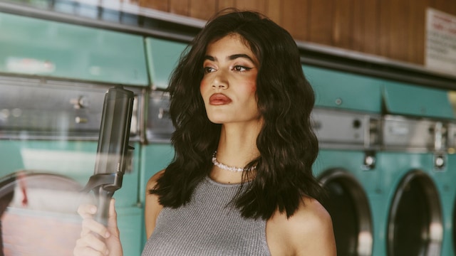 Mujer con pelo moreno ondulado y rizador de ondas ghd wave