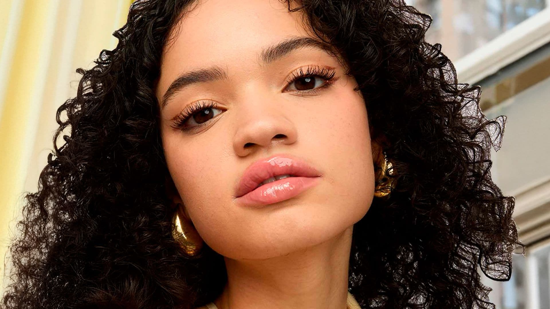 Rostro de mujer con pelo rizado y labios jugosos y brillantes