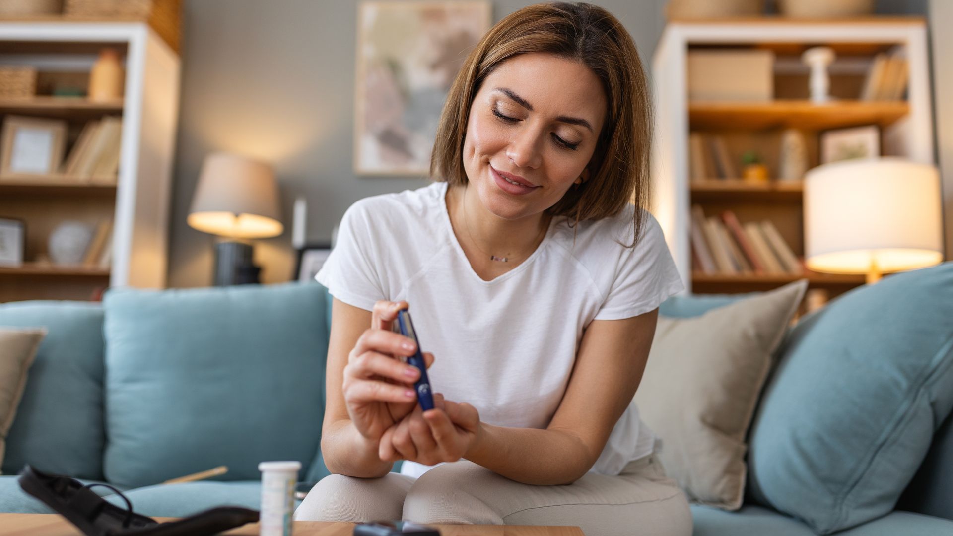 mujer midiendo sus niveles de glucosa en casa