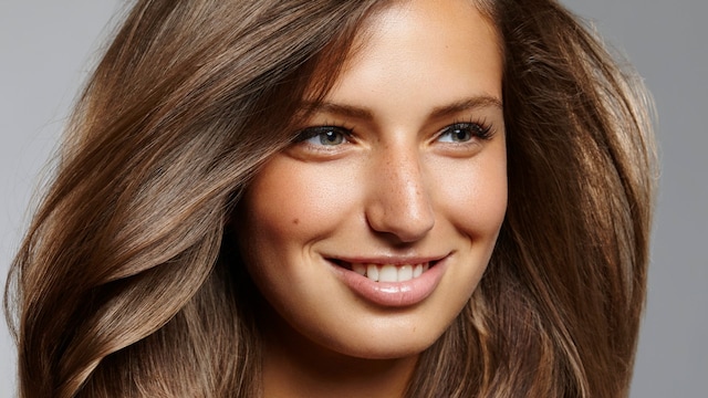 Rostro de mujer morena con pelo voluminoso y pestañas largas