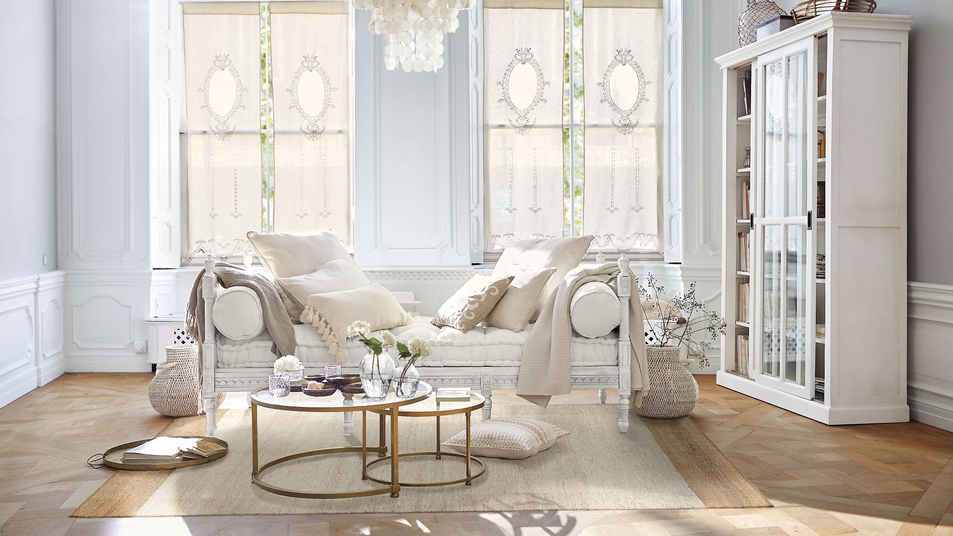 Salón con chaise longue, lámpara de techo, vitrina blanca, mesa de centro, grandes ventanales, alfombra