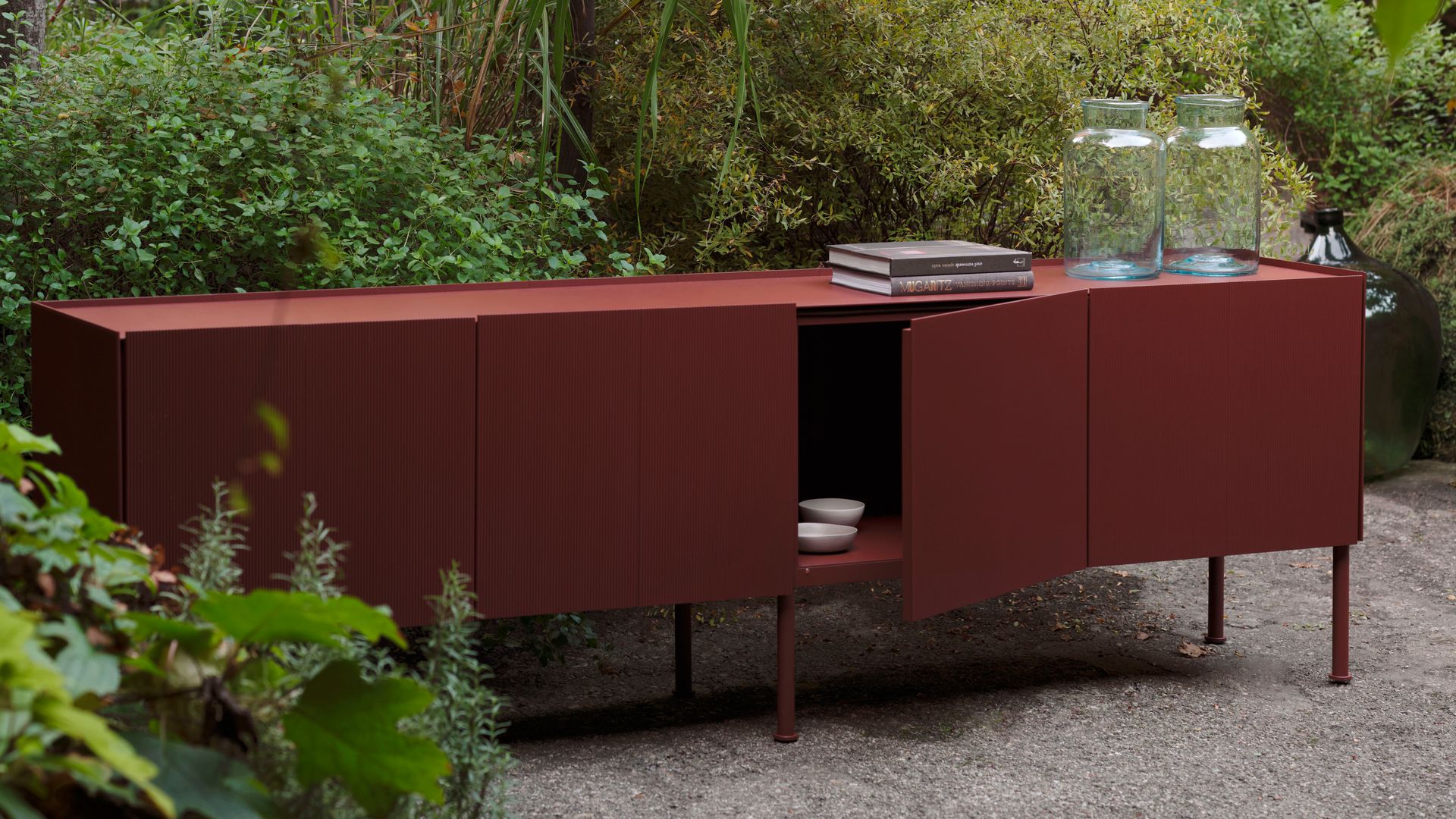 Aparador de exterior de aluminio pintado de color rojo en un jardín 