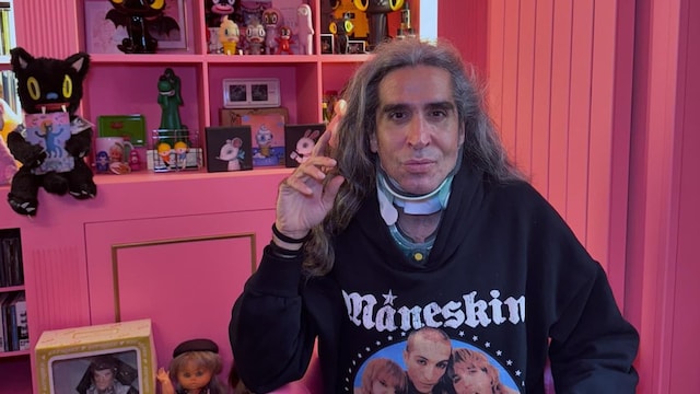 Mario Vaquerizo posando sentado con un collarín cervical y ropa de calle