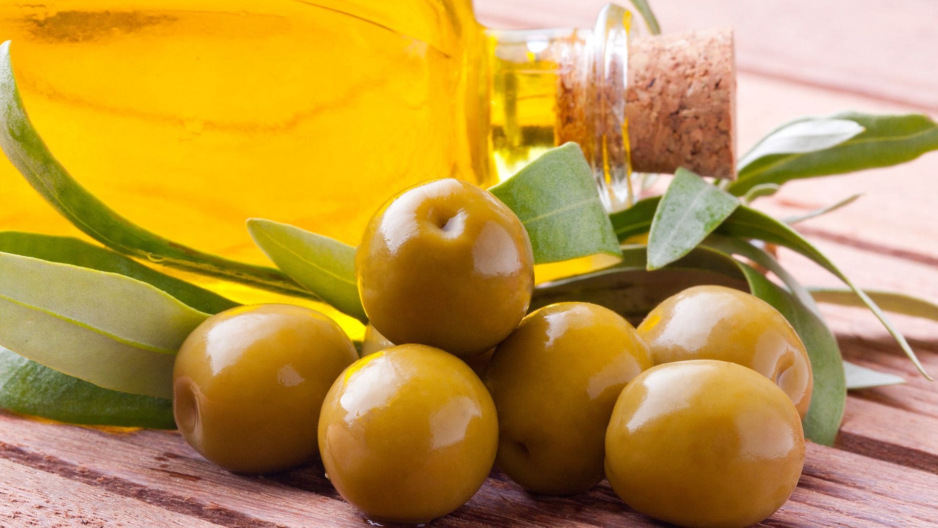 Aceitunas verdes con aceite y hojas