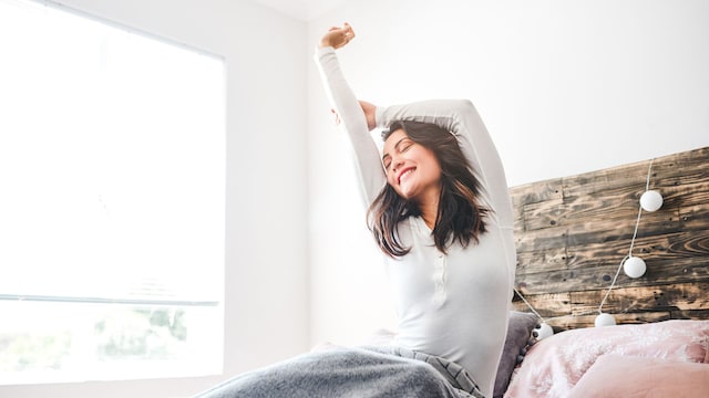 Mujer en la cama feliz de dormir bien