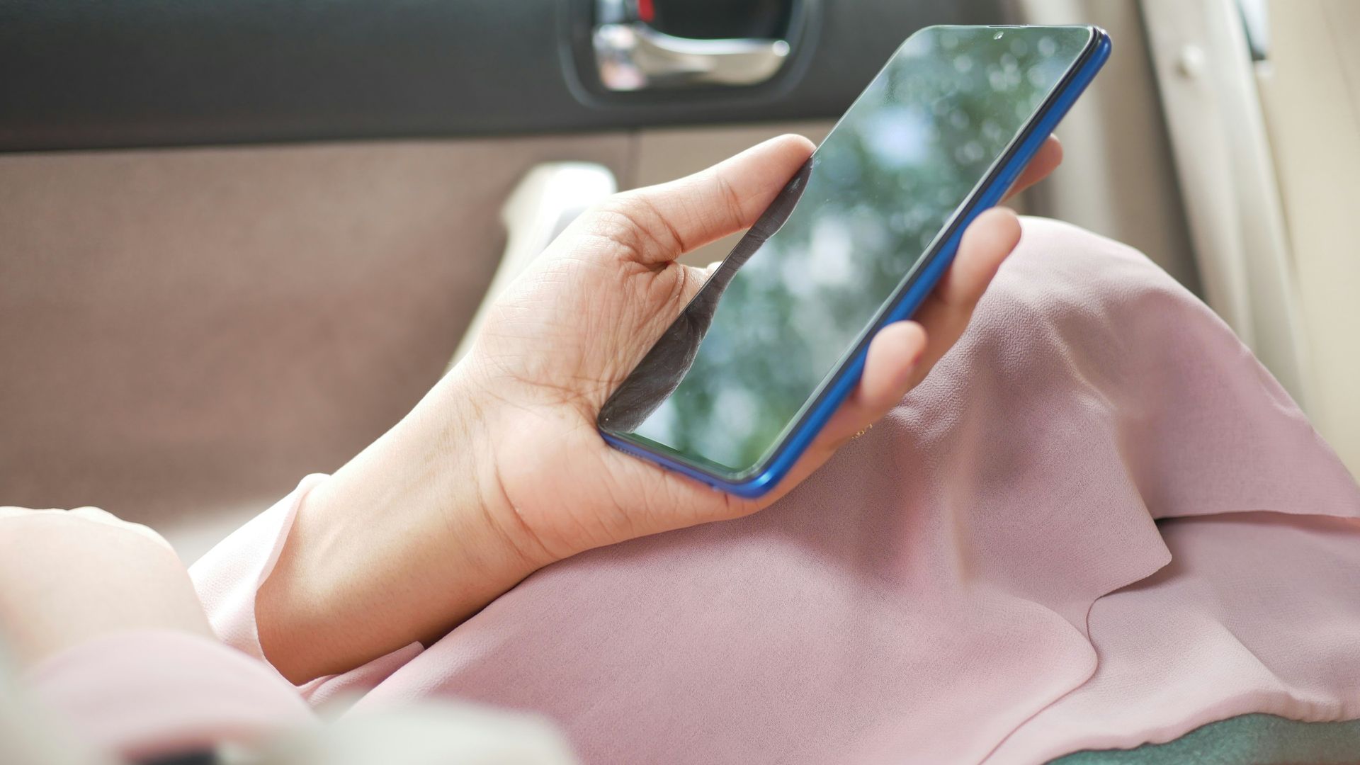 Una mujer en un coche usando su teléfono móvil