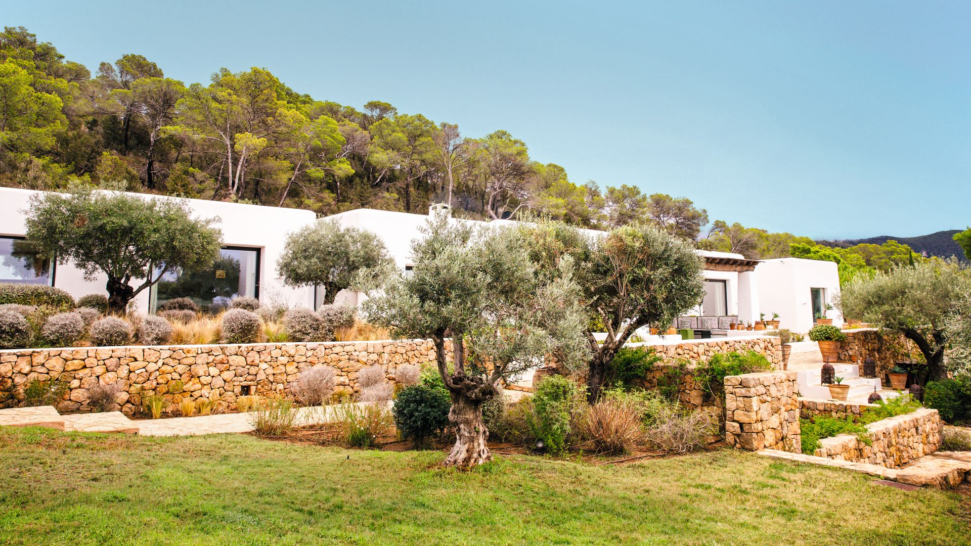 Dos imágenes del exterior de la casa de Emma Roig en Ibiza, una villa que construyeron desde cero