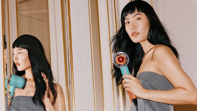 Mujer secándose el pelo con secador Dyson Supersonic Nural
