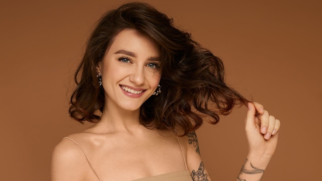 Mujer morena con pelo corto agarrándose un mechón
