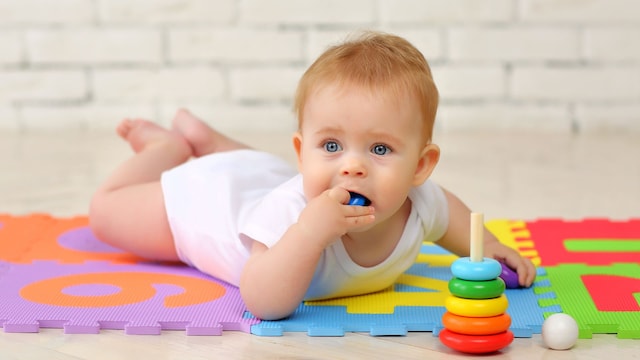 Niño pequeño con una pieza de un juguete en la boca con riesgo de atragantamiento.