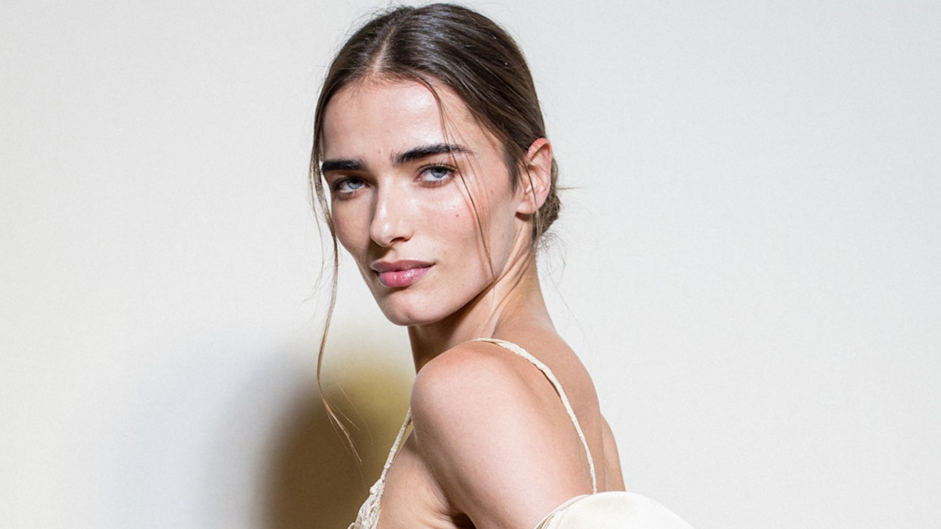 Modelo en el backstage de Elie Saab con vestido blanco royo y recogido