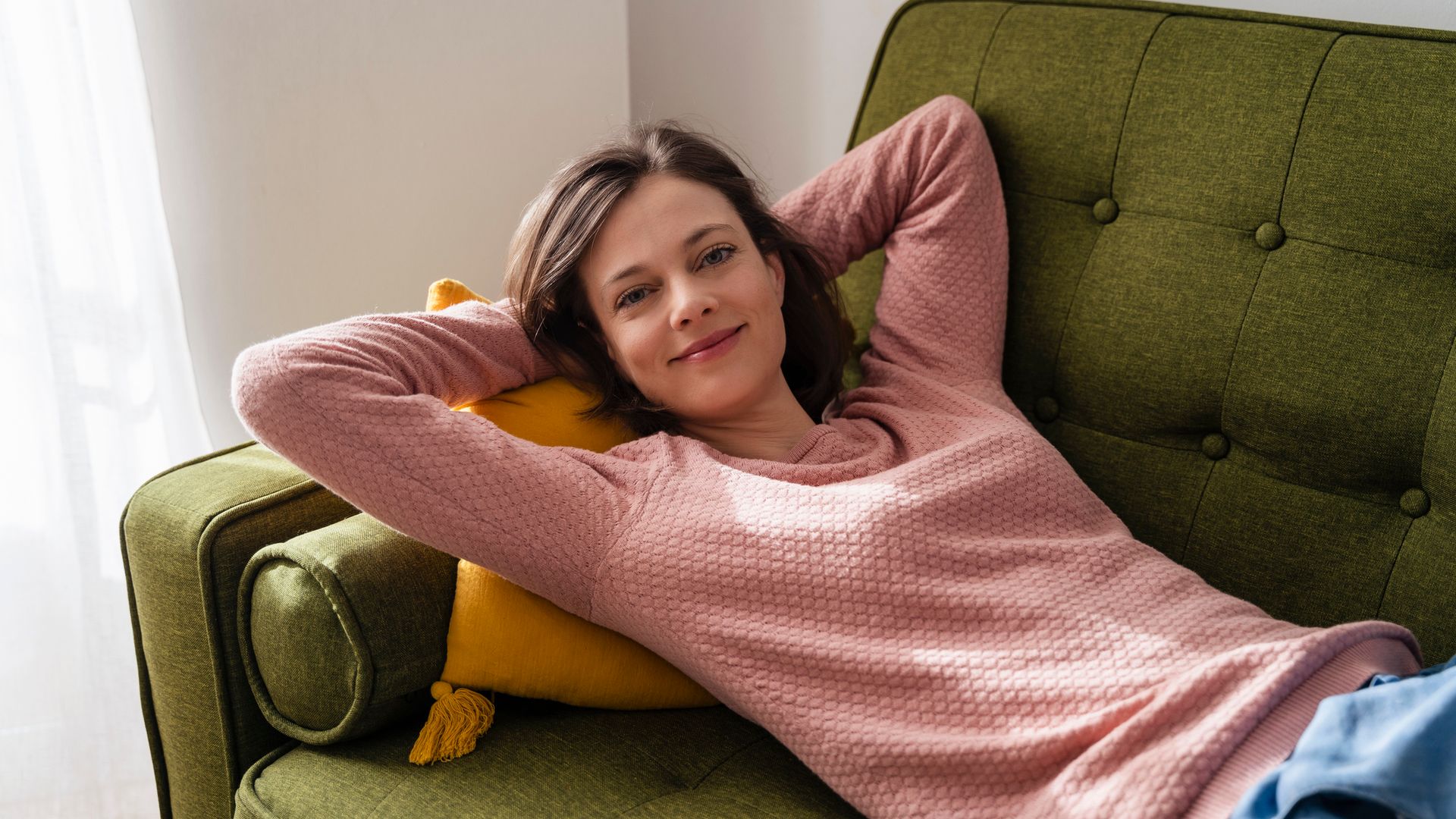 Mujer en calma en el sofá mirando a cámara 