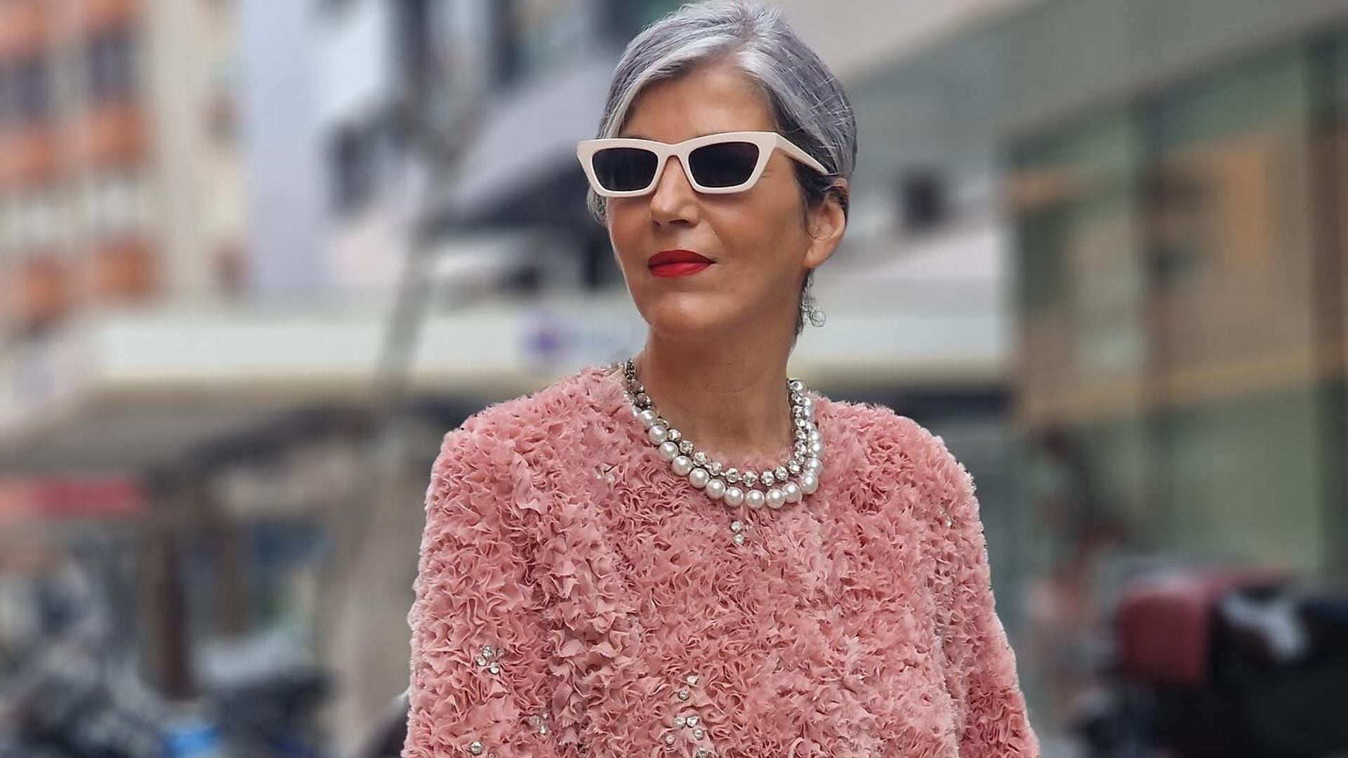 Carmen Gimeno con chaqueta rosa texturizada, vaqueros y collar de perlas