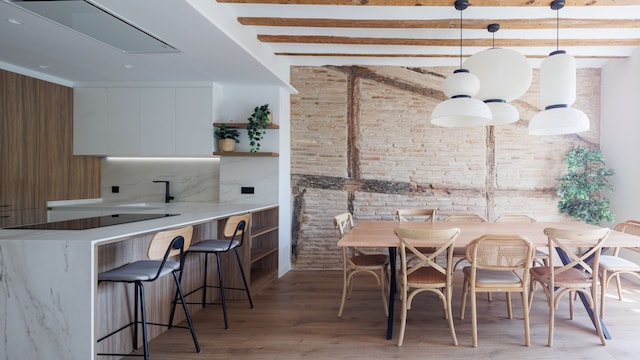 Comedor y cocina abierta con pared de ladrillo visto y recuperada