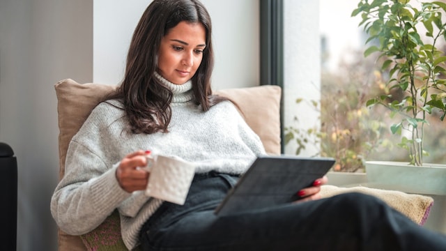Una mujer leyendo con una taza 