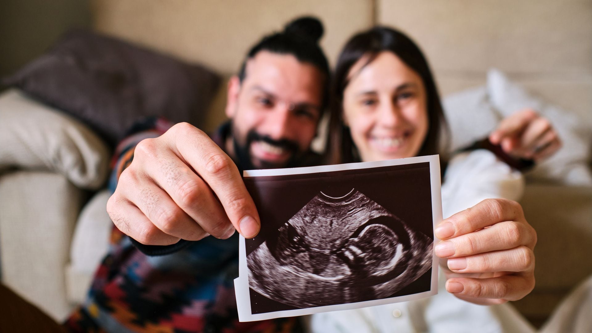 Pareja muestra, feliz, ecografía de su bebé