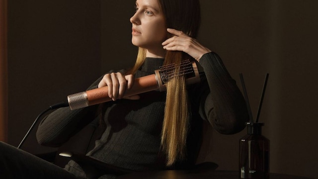 Una chica con una herramienta de calor para su cabello