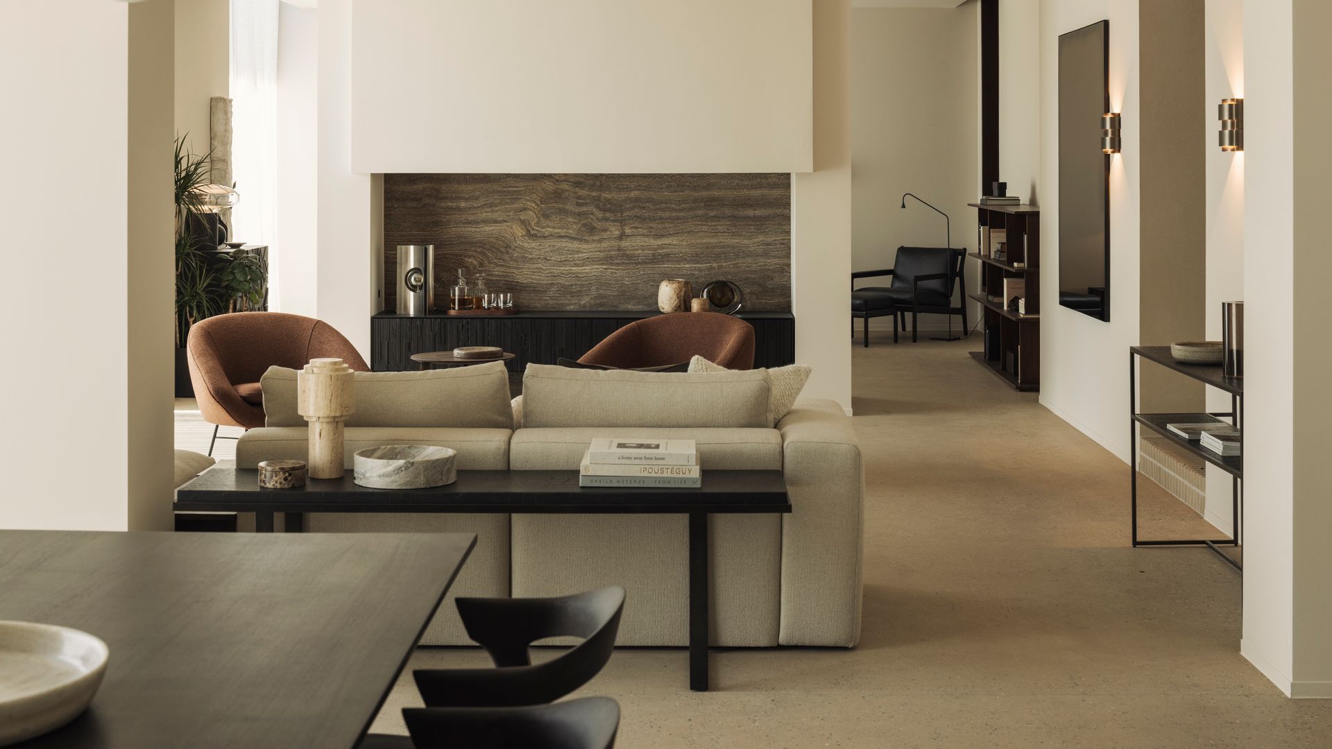 Salón comedor con sofá beige, banco negro en la trasera del sofá, mesa de comedor negra, sillas de comedor negras