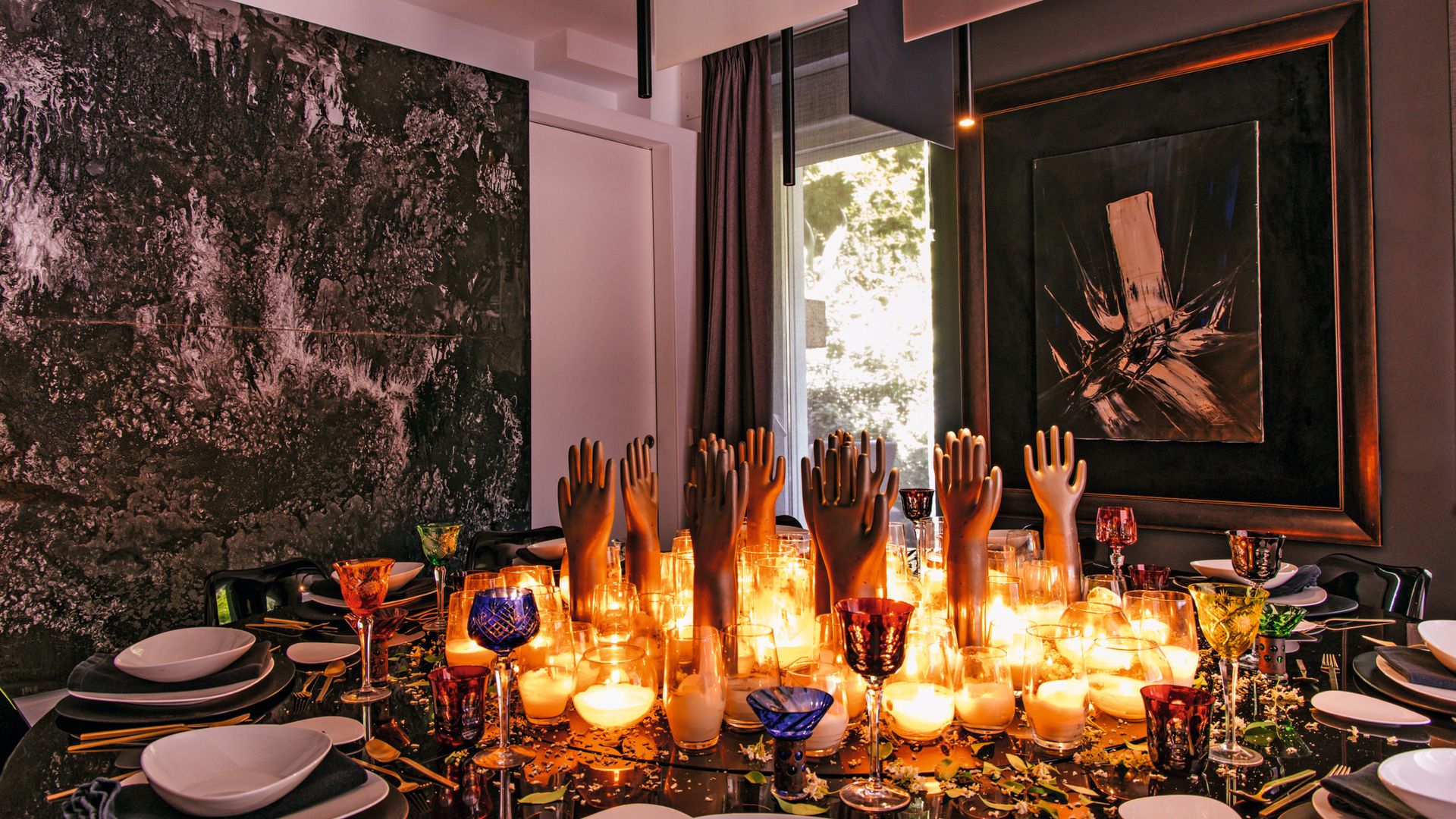 Un detalle de la decoración de la mesa, presidida por un conjunto de esculturas adquiridas en anticuarios: antiguos moldes metálicos procedentes de una fábrica de guantes. La cristalería es de Christofle y la vajilla, de Alvar Aalto.