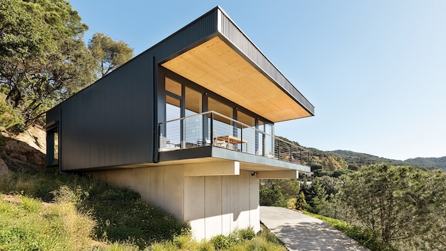 Casa en un bosque con fachada negra y terraza con vistas al paisaje