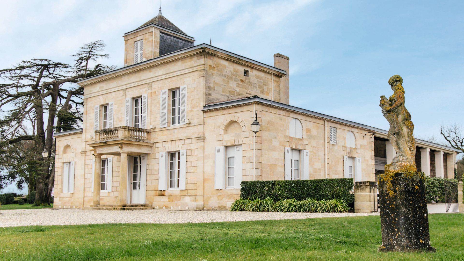 La entrada principal del "château", rodeado de varias construcciones destinadas a la vida familiar y a la acogida de invitados. El edificio, ejemplo de la elegancia clásica del Burdeos del siglo XVIII, destaca por su fachada neoclásica, levantada en la característica piedra caliza de la región, cuya luz envuelve toda la propiedad