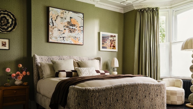 Dormitorio con papel pintado verde, cortinas a juego, molduras decorativas, cama tapizada