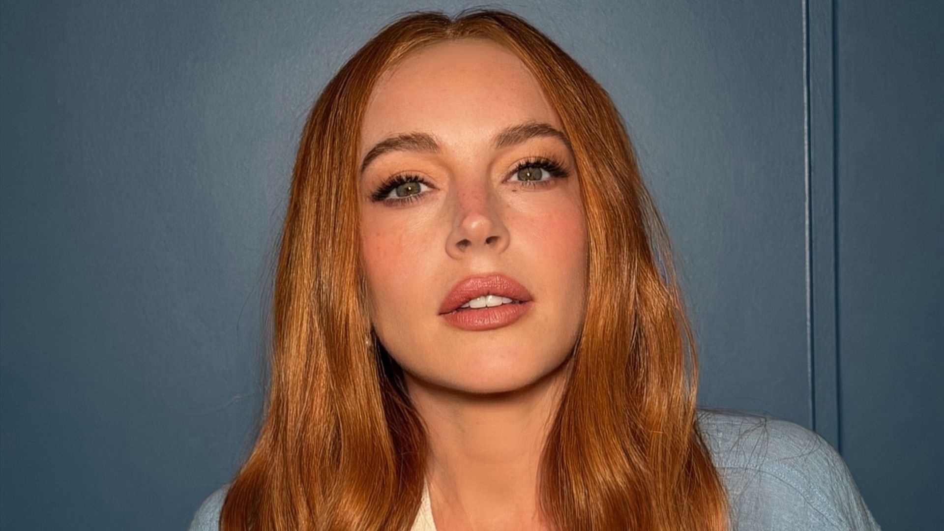 Lindsay Lohan con pelo pelirrojo largo, kimino azul con vivo blanco