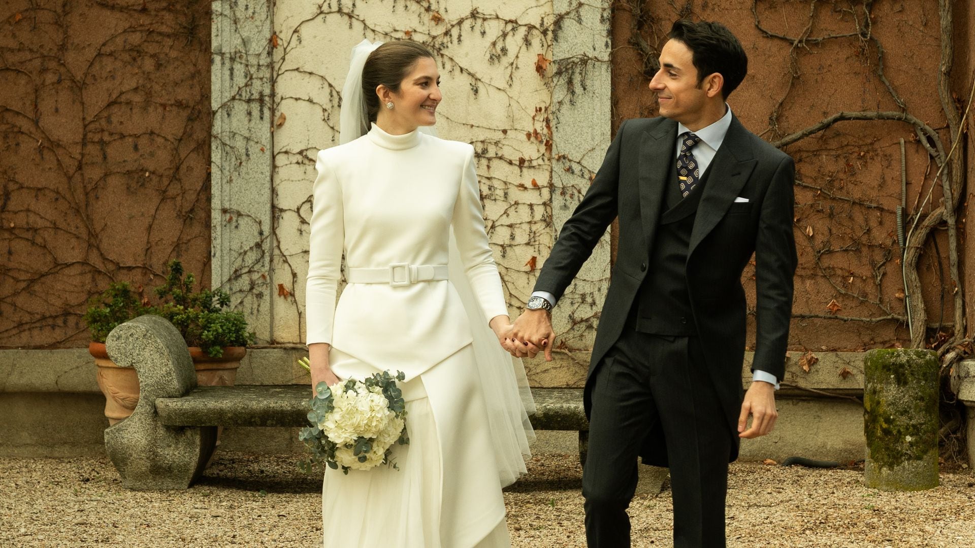 Un vestido de novia sin mangas, una chaqueta asimétrica y un cinturón: la elección de Mónica para su boda en Madrid
