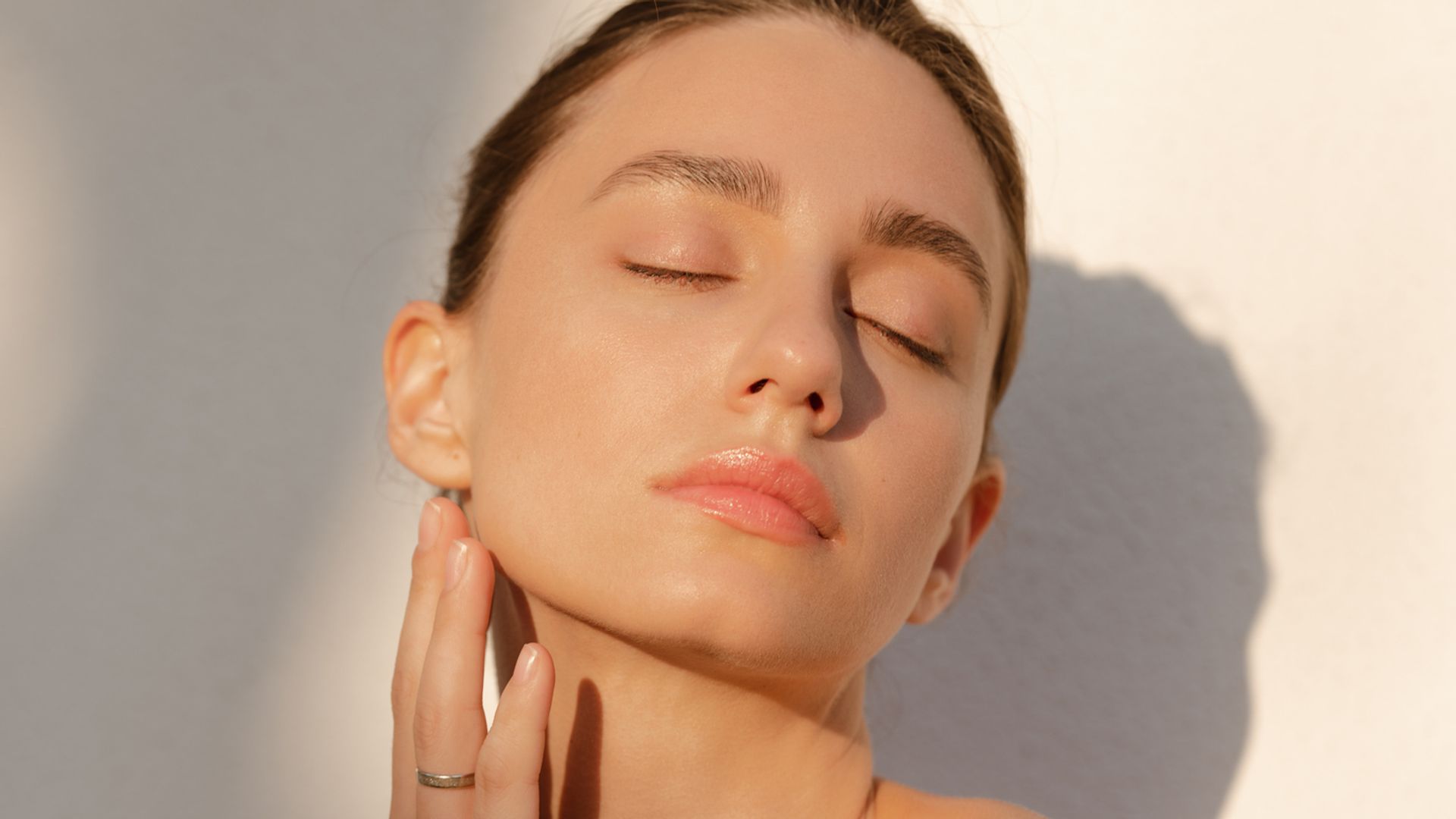 Rostro de mujer besada por el sol con los ojos cerrados
