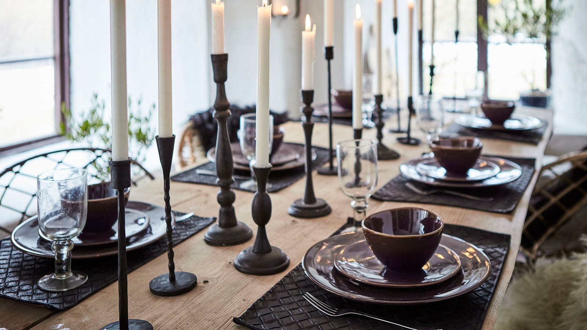 Mesa con velas y manteles individuales, vajilla marrón