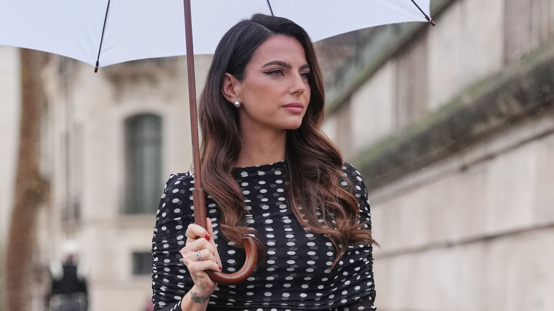 Kelly Piuquet con vestido corto de lunares y paraguas en Paris