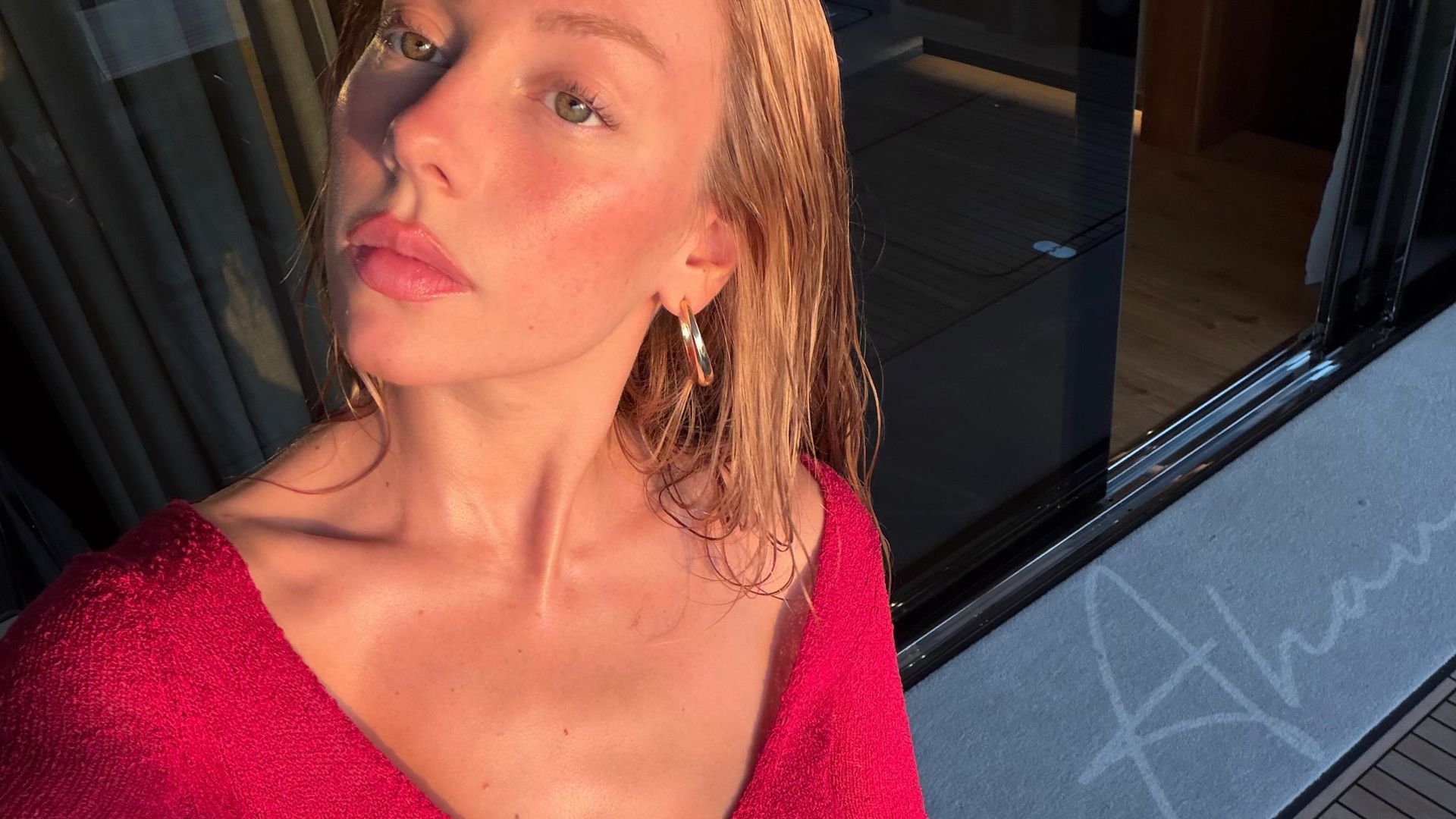 Ester Expósito con conjunto rojo cereza y maquillaje natural