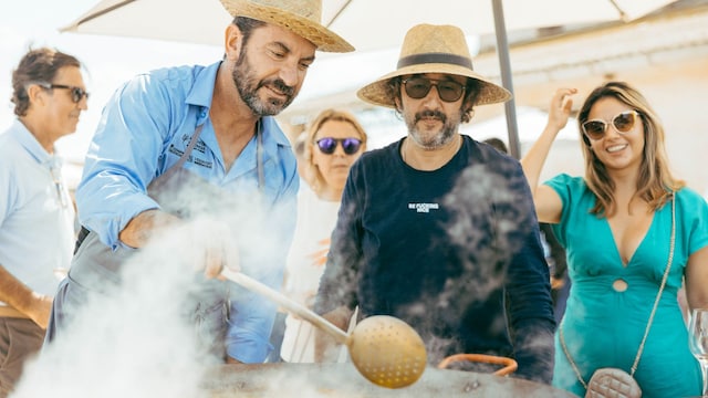 Arturo Valls cocinando una paella entre amigos.